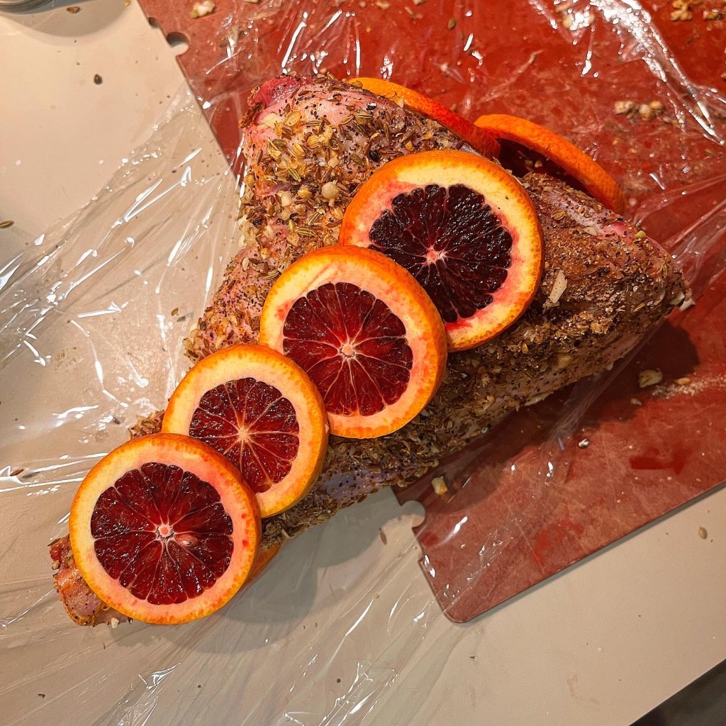 Uncooked Lamb shank, dressed up with dry marinate and blood oranges. 